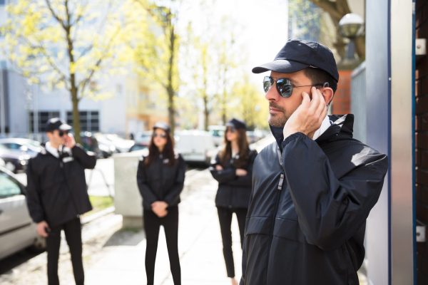 Close-up Of A Young Male Security Guard Listening With Earpiece